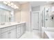 Contemporary bathroom with dual sinks, white cabinetry, tile flooring, and a glass shower with a tub at 1984 Shadetree Blvd, Johns Island, SC 29455