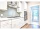 A modern kitchen featuring white cabinets, stainless steel appliances, and a stylish backsplash providing a sleek cooking space at 1984 Shadetree Blvd, Johns Island, SC 29455