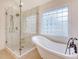 Bright bathroom with walk-in shower that has white marble surround and a free standing tub next to window at 2072 Middleburg Ln, Mount Pleasant, SC 29464