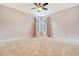 Empty bedroom with neutral carpet, ceiling fan and two windows with pink curtains at 2072 Middleburg Ln, Mount Pleasant, SC 29464