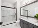 Bathroom showcasing a marble tiled shower with glass door, gray vanity with a modern mirror, and ample space at 2200 Belle Isle Ave # 103, Mount Pleasant, SC 29464