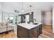 Open-concept kitchen with island, bar stools, stainless appliances, and a view into the living area at 2200 Belle Isle Ave # 103, Mount Pleasant, SC 29464