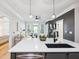 Open-concept kitchen with island, bar stools, stainless appliances, and a view into the living area at 2200 Belle Isle Ave # 103, Mount Pleasant, SC 29464