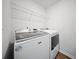 Bright laundry room features white washer and dryer, convenient wire shelving, and neutral walls at 225 Sedona Dr, Summerville, SC 29486