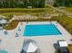 Community swimming pool with lap lanes, lounge chairs, and umbrellas, surrounded by greenery and a pond at 225 Sedona Dr, Summerville, SC 29486