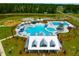 Aerial view of community pool area featuring pools, lounge chairs, and a splash pad with lush landscaping at 225 Sedona Dr, Summerville, SC 29486