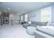 Comfortable upper living room with plush gray sofa, ottoman, and plentiful natural light from the surrounding windows at 2322 Dorado Ct, Johns Island, SC 29455
