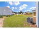 A spacious backyard with an energy-efficient air conditioning unit and a view of neighborhood homes at 234 Silk Oak Dr, Moncks Corner, SC 29461