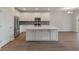 Spacious kitchen with island, stainless appliances, white cabinets, and wood floors at 234 Silk Oak Dr, Moncks Corner, SC 29461