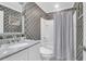 Stylish bathroom featuring patterned wallpaper, a bathtub with shower, and a marble countertop sink at 2353 Eagle Creek Dr, Charleston, SC 29414