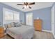 Cozy bedroom featuring blue walls, a ceiling fan, and a comfortable bed with nautical-themed pillows at 2353 Eagle Creek Dr, Charleston, SC 29414