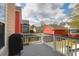 Outdoor deck with a grill, overlooking a green backyard with flowering bushes and mature trees at 2353 Eagle Creek Dr, Charleston, SC 29414