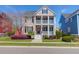 Charming two-story home featuring double balconies, well-manicured lawn, and a vibrant red front door at 2353 Eagle Creek Dr, Charleston, SC 29414