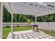 Inviting backyard with a pergola, string lights, and a modern grill, perfect for outdoor entertaining at 243 N Light Way, Summerville, SC 29486