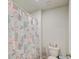 Bright bathroom featuring a patterned shower curtain, white toilet, and minimalist decor at 243 N Light Way, Summerville, SC 29486