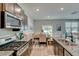 Open kitchen with stainless steel appliances, granite countertops, and a view into the dining area at 243 N Light Way, Summerville, SC 29486