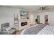 Serene main bedroom with electric fireplace, tv, board and batten wall design and ceiling fan at 243 N Light Way, Summerville, SC 29486