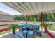 Covered patio with cozy seating area, outdoor dining, and lush greenery, ideal for relaxation at 243 N Light Way, Summerville, SC 29486