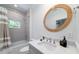 Comfortable bathroom featuring an elegant round mirror, white marble flooring and a shower over tub at 2501 Clear Marsh Rd, Seabrook Island, SC 29455