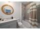 Charming bathroom featuring a bathtub and shower, a wood trimmed round mirror, and elegant marble flooring at 2501 Clear Marsh Rd, Seabrook Island, SC 29455