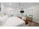 Bright bedroom with hardwood floors, white walls, a ceiling fan, and three windows for abundant natural light at 2501 Clear Marsh Rd, Seabrook Island, SC 29455