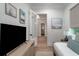 Bright bedroom featuring wood floors, artwork, and an open door to ensuite bathroom at 2501 Clear Marsh Rd, Seabrook Island, SC 29455