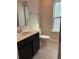 Bathroom with dark vanity, white sink, toilet, and a bright window at 280 Godwit Dr, Summerville, SC 29486