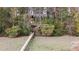 Exterior view of a home accessible via a wooden boardwalk and stairs through a lush, natural landscape at 3020 Plumier Pl, Charleston, SC 29414