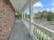 View of a beautiful balcony, with gray flooring, brick and white supports, overlooking a landscaped exterior at 3025 Lazarette Ln, Charleston, SC 29414