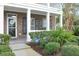 Inviting front porch with brick columns, black shutters, and meticulously maintained landscaping at 3025 Lazarette Ln, Charleston, SC 29414