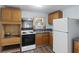 Functional kitchen with white appliances, wooden cabinetry, and a double basin sink under the window at 311 Black St, Walterboro, SC 29488