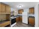 Well-lit kitchen featuring wooden cabinets, a white refrigerator, and a stove, perfect for home cooking at 311 Black St, Walterboro, SC 29488