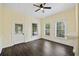 Bright living room enhanced by natural light, complemented by dark wood floors and a ceiling fan for added comfort at 311 Black St, Walterboro, SC 29488