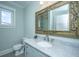 Beautiful bathroom with a light blue vanity with a white marble top and gold trimmed mirror at 3419 Myrtle St, Edisto Island, SC 29438