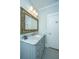 Bathroom with a light blue vanity with a white marble top, gold trimmed mirror, and tile floors at 3419 Myrtle St, Edisto Island, SC 29438