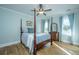 Relaxing bedroom featuring a four-poster bed, hardwood floors, and soft blue walls at 3419 Myrtle St, Edisto Island, SC 29438