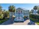 Charming coastal home with a brick driveway, staircase, and lush tropical landscaping at 3419 Myrtle St, Edisto Island, SC 29438