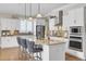 Kitchen with white cabinets, tile backsplash, marble countertops, stainless steel appliances, and bar seating at 345 Turnstone St, Mount Pleasant, SC 29464