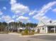 The side of a clubhouse is pictured, surrounded by lush landscaping with palm trees against a bright blue, partly cloudy sky at 413 Cedarview Rd, Summerville, SC 29486