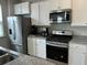 Modern kitchen featuring granite counters, white cabinets, stainless steel appliances, and stainless steel sink at 413 Cedarview Rd, Summerville, SC 29486