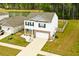 Aerial of home featuring white siding and brick accents, set on a landscaped lot near a pond and surrounded by trees at 436 Cedarview Rd, Summerville, SC 29486