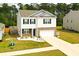 Aerial view features white siding, brick accents, well-maintained lawn, and tree-lined backdrop at 436 Cedarview Rd, Summerville, SC 29486