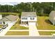 Aerial shot showcases the house with white siding and brick features, located near a pond and lush green spaces at 436 Cedarview Rd, Summerville, SC 29486
