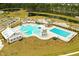 A vibrant aerial view of the community pool area featuring a splash pad, playground, and plenty of lounge chairs at 436 Cedarview Rd, Summerville, SC 29486
