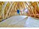 Spacious unfinished attic space with wooden beams and natural light from a central window at 4846 Causey Pond Rd, Awendaw, SC 29429