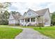 Beautiful two-story home with stone accents, a gravel driveway, and a welcoming front porch at 4846 Causey Pond Rd, Awendaw, SC 29429