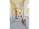 Relaxing covered porch with white columns, a porch swing, and a view of the surrounding trees at 4846 Causey Pond Rd, Awendaw, SC 29429