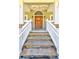 Inviting front porch with stone steps, white railing, and a wood door with arched window at 4846 Causey Pond Rd, Awendaw, SC 29429