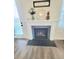 Living room fireplace decorated with a modern clock and floral arrangement at 609 Sienna Way, Summerville, SC 29486