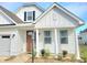 Lovely home showcasing a modern design with covered porch and lush landscaping at 609 Sienna Way, Summerville, SC 29486